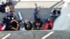 Refugees rest in the shadow after arriving in Freilassing at the border between Austria and Germany, southern Germany, Sept. 16, 2015.