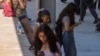 Students use their cellphones as they leave for the day the Ramon C. Cortines School of Visual and Performing Arts High School in downtown Los Angeles, Aug. 13, 2024.