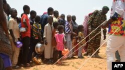 Children queue for food distributed by an NGO in the makeshift camp of Saguia near the capital Niamey, on Sept. 11, 2019, after the Niger river floods forced residents from the area.