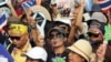 Anti-government protesters, one holds a picture of Thai King Bhumibol Adulyadej, chant slogans during a demonstration against an amnesty bill in Bangkok, Thailand, Nov. 11, 2013. 