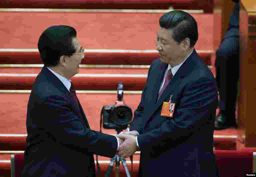 Presiden China yang baru terpilih, Xi Jinping berjabat tangan dengan mantan Presiden Hu Jintao yang digantikannya, dalam rapat pleno keempat Kongres Rakyat Nasional di Balai Agung Rakyat di Beijing.