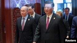 Russia's President Vladimir Putin (L) with Chinese President Xi Jinping 