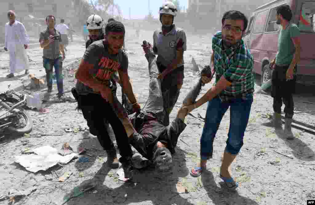 Para petugas penyelamatan Suriah dan warga sipil mengevakusi seorang pria di distrik Maadi, menyusul serangan bom drum di Aleppo timur (27/8). (AFP/Ameer Alhalbi)