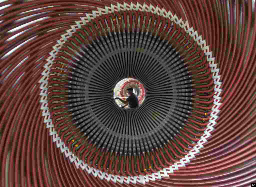 Electrical machine builder Oleg Glebov works at the stator windings of a generator in the Erfurt Generator Plant of the German Siemens AG in Erfurt, central Germany.