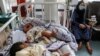 A woman sits next to newborn babies who lost their mothers following a suicide attack in a maternity hospital, in Kabul, Afghanistan, May 13, 2020.