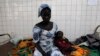 FILE - A woman sits beside her sick child in the pediatric ward at the general hospital in Man, western Ivory Coast, July 4, 2013. 
