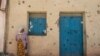 FILE - A woman leans on the wall of a damaged house that was shelled as federal-aligned forces entered the city, in Wukro, north of Mekele, capital of Tigray, March 1, 2021.