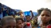 FILE - A girl balances a bowl of food on her head at an Internally Displaced People's (IDP) camp in Faladie, where hundreds have found refuge after fleeing inter-communal violence in central Mali, May 14, 2019.