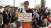ស្ត្រីម្នាក់​ដើរ​កាន់​​បដា​​មួយ​​លើ​ឆាក​​​បង្ហាញ​ពី​ការ​ចង់​បាន​របស់​ពលរដ្ឋ ​ដើម្បី​អបអរ​ក្នុង​​ពិធី​​​​ប្រារព្ធ​ទិវា​សិទ្ធិ​នារី​អន្តរជាតិ​លើក​ទី​១០៩ នៅ​សួន​ប្រជាធិបតេយ្យ ​ថ្ងៃ​ទី៨ ខែ​មីនា ឆ្នាំ​២០២០។ (កាន់ វិច្ឆិកា/VOA) 