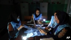 Afghan election workers count ballots in the presidential elections at a polling station in Kabul, Afghanistan, Sept. 28, 2019. An unofficial estimate put voter turnout at a little more than 2 million voters out of nearly 10 million.