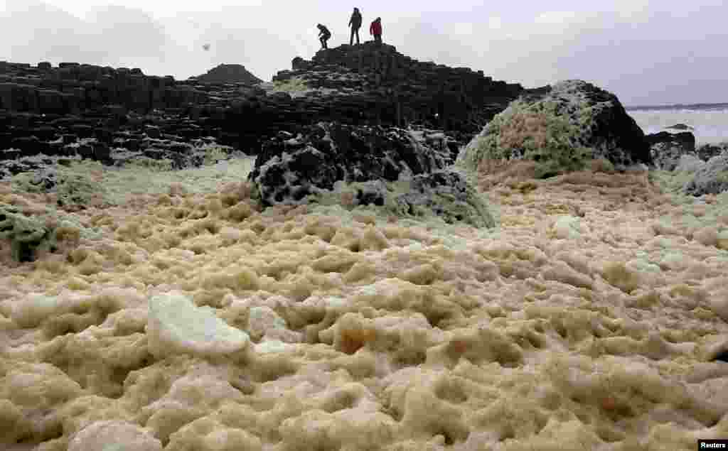 Tourists stand on the Giant's Causeway near the town of Bushmills on the north Antrim coast in northern Ireland.