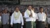 Aung Thein Lin, center, a retired Yangon mayor accompanied by Aung Win, second from left, a candidate of government backed Union Solidarity and Development Party (USDP), speaks to supporters during an election campaign in Dagon Port township, in Yangon, 