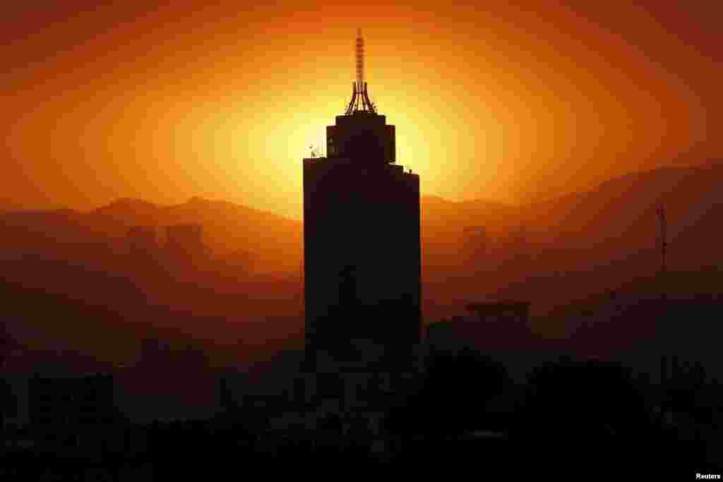The sun sets behind the World Trade Center building in Mexico City, March 14, 2016.