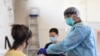 A healthcare worker prepares to conduct a coronavirus disease (COVID-19) test on a patient at a testing facility in Melbourne, Australia, Aug. 20, 2020. 